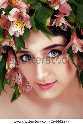 Girl with flower wreath. Caucasian woman with gray eyes and brown hair wearing bright fucsia makeup close up