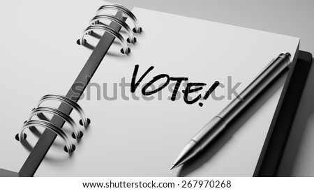 Closeup of a personal agenda with a Ballpoint pen marking a day of the month representing a organizing time and schedule. Vote! text note reminder concept. Words Vote! written in Black Marker.
