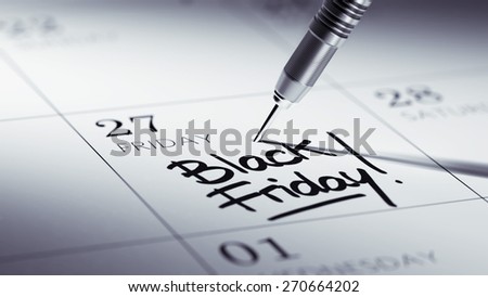 Concept image of a Calendar with a golden dart stick. The words Black Friday written on a white notebook to remind you an important appointment.