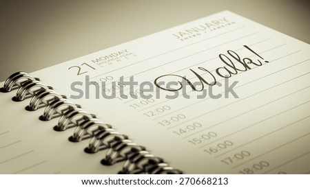 Closeup of a personal calendar setting an important date representing a time schedule. The words Walk written on a white notebook to remind you an important appointment.