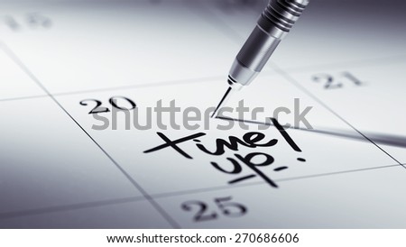 Concept image of a Calendar with a golden dart stick. The words Time up written on a white notebook to remind you an important appointment.