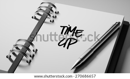 Closeup of a personal agenda setting an important date writing with pen. The words Time up written on a white notebook to remind you an important appointment.