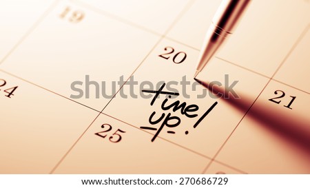 Closeup of a personal agenda setting an important date written with pen. The words Time up written on a white notebook to remind you an important appointment.
