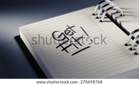 Closeup of a personal agenda setting an important date representing a time schedule. The words Get Fit! written on a white notebook to remind you an important appointment.