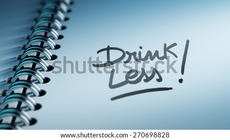 Closeup of a personal calendar setting an important date representing a time schedule. The words Drink Less written on a white notebook to remind you an important appointment.