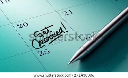Closeup of a personal agenda setting an important date written with pen. The words Get Married written on a white notebook to remind you an important appointment.