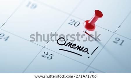 Concept image of a Calendar with a red push pin. Closeup shot of a thumbtack attached. The words Cinema written on a white notebook to remind you an important appointment.