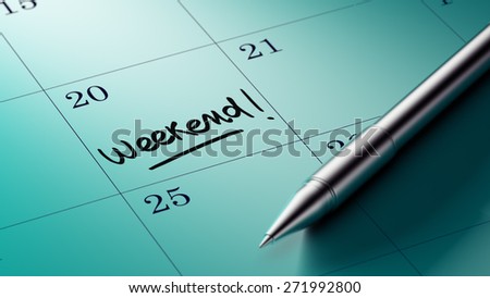 Closeup of a personal agenda setting an important date written with pen. The words Weekend written on a white notebook to remind you an important appointment.