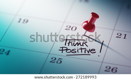 Concept image of a Calendar with a red push pin. Closeup shot of a thumbtack attached. The words Think positive written on a white notebook to remind you an important appointment.
