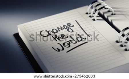Closeup of a personal agenda setting an important date representing a time schedule. The words Change the world written on a white notebook to remind you an important appointment.
