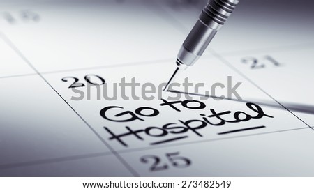 Concept image of a Calendar with a golden dart stick. The words Go to Hospital written on a white notebook to remind you an important appointment.