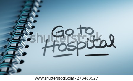 Closeup of a personal calendar setting an important date representing a time schedule. The words Go to Hospital written on a white notebook to remind you an important appointment.