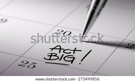 Closeup of a personal agenda setting an important date written with pen. The words Act BIG written on a white notebook to remind you an important appointment.