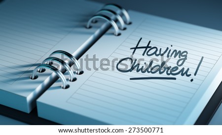 Closeup of a personal agenda setting an important date representing a time schedule. The words Having Children written on a white notebook to remind you an important appointment.
