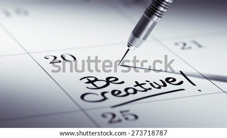 Concept image of a Calendar with a golden dart stick. The words Be Creative written on a white notebook to remind you an important appointment.