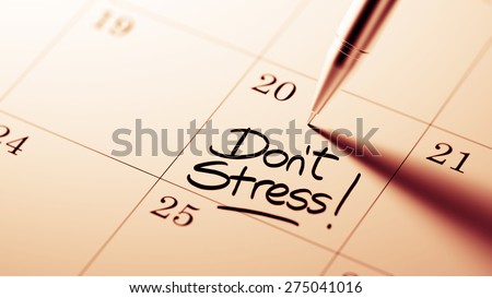 Closeup of a personal agenda setting an important date written with pen. The words Don\'t Stress written on a white notebook to remind you an important appointment.