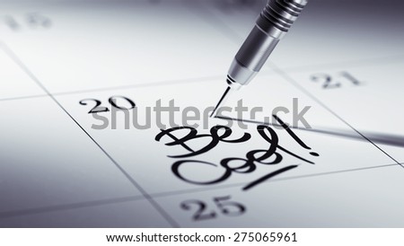 Concept image of a Calendar with a golden dart stick. The words Be cool written on a white notebook to remind you an important appointment.