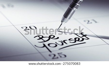 Concept image of a Calendar with a golden dart stick. The words be yourself written on a white notebook to remind you an important appointment.