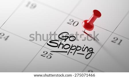 Concept image of a Calendar with a red push pin. Closeup shot of a thumbtack attached. The words Go shopping written on a white notebook to remind you an important appointment.