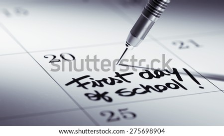 Concept image of a Calendar with a golden dart stick. The words First day of school written on a white notebook to remind you an important appointment.