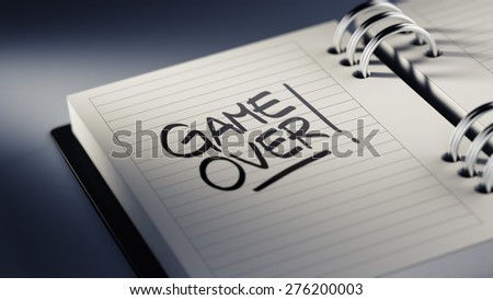 Closeup of a personal agenda setting an important date representing a time schedule. The words Game over written on a white notebook to remind you an important appointment.