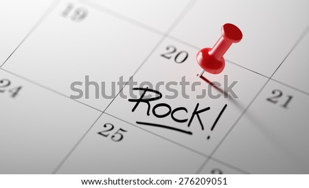 Concept image of a Calendar with a red push pin. Closeup shot of a thumbtack attached. The words Rock written on a white notebook to remind you an important appointment.