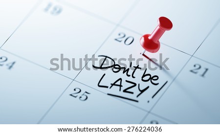 Concept image of a Calendar with a red push pin. Closeup shot of a thumbtack attached. The words Don\'t be Lazy written on a white notebook to remind you an important appointment.