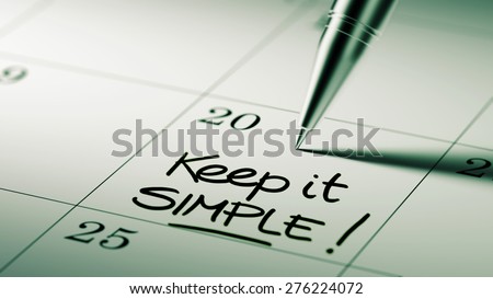Closeup of a personal agenda setting an important date written with pen. The words Keep it Simple written on a white notebook to remind you an important appointment.