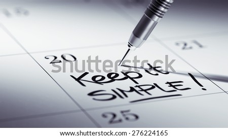 Concept image of a Calendar with a golden dart stick. The words Keep it Simple written on a white notebook to remind you an important appointment.