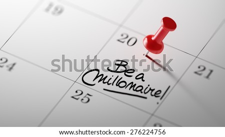 Concept image of a Calendar with a red push pin. Closeup shot of a thumbtack attached. The words Be a millionaire written on a white notebook to remind you an important appointment.