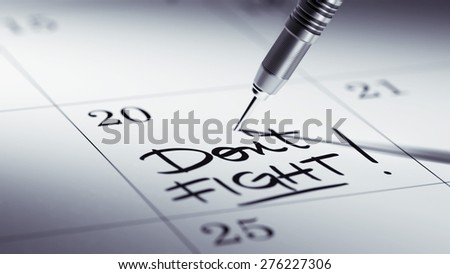 Concept image of a Calendar with a golden dart stick. The words Don\'t Fight written on a white notebook to remind you an important appointment.