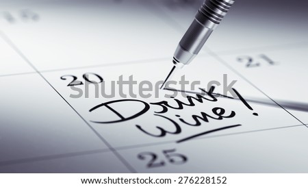 Concept image of a Calendar with a golden dart stick. The words Drink Wine written on a white notebook to remind you an important appointment.