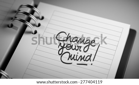 Closeup of a personal agenda setting an important date representing a time schedule. The words Change your Mind written on a white notebook to remind you an important appointment.