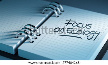 Closeup of a personal agenda setting an important date representing a time schedule. The words Focus on Ecology written on a white notebook to remind you an important appointment.