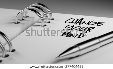 Closeup of a personal agenda setting an important date writing with pen. The words Change your Mind written on a white notebook to remind you an important appointment.