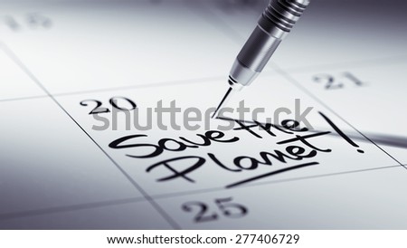 Concept image of a Calendar with a golden dart stick. The words Save the Planet written on a white notebook to remind you an important appointment.