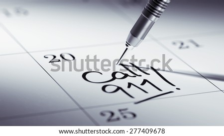 Concept image of a Calendar with a golden dart stick. The words Call 911 written on a white notebook to remind you an important appointment.
