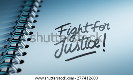 Closeup of a personal calendar setting an important date representing a time schedule. The words Fight for Justice written on a white notebook to remind you an important appointment.
