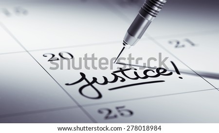 Concept image of a Calendar with a golden dart stick. The words Justice written on a white notebook to remind you an important appointment.