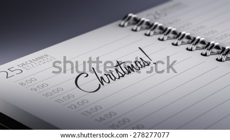 Closeup of a personal calendar setting an important date representing a time schedule. The words Christmas written on a white notebook to remind you an important appointment.