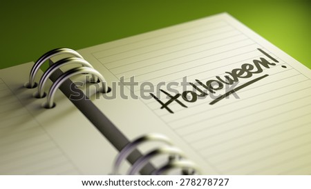 Closeup of a personal agenda setting an important date representing a time schedule. The words Halloween written on a white notebook to remind you an important appointment.
