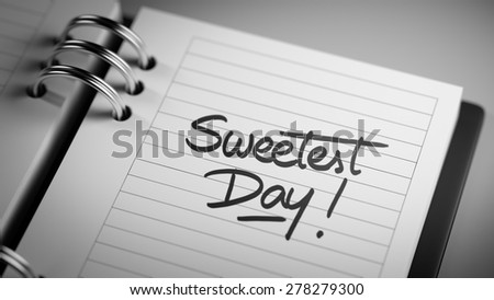 Closeup of a personal agenda setting an important date representing a time schedule. The words Sweetest Day written on a white notebook to remind you an important appointment.