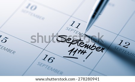 Closeup of a personal agenda setting an important date written with pen. The words September 11th written on a white notebook to remind you an important appointment.