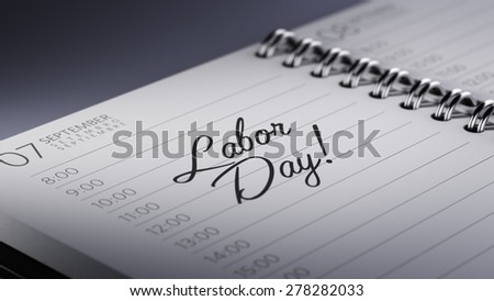 Closeup of a personal calendar setting an important date representing a time schedule. The words Labor Day written on a white notebook to remind you an important appointment.
