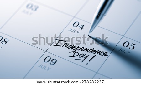Closeup of a personal agenda setting an important date written with pen. The words Independence Day written on a white notebook to remind you an important appointment.