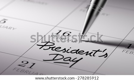 Closeup of a personal agenda setting an important date written with pen. The words President's Day written on a white notebook to remind you an important appointment.