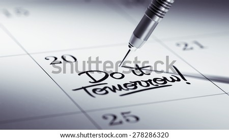 Concept image of a Calendar with a golden dart stick. The words Do it Tomorrow written on a white notebook to remind you an important appointment.