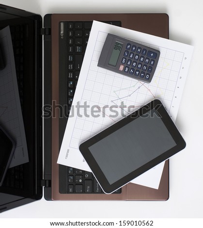 Computer, Digital Tablet, Calculator and Chart on the Desk