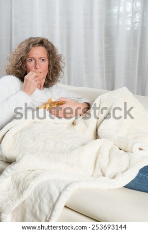 woman eating chips and looking TV
