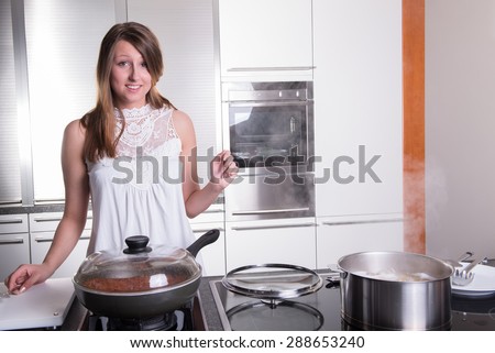 attractive student cooking bolognese sauce in kitchen
